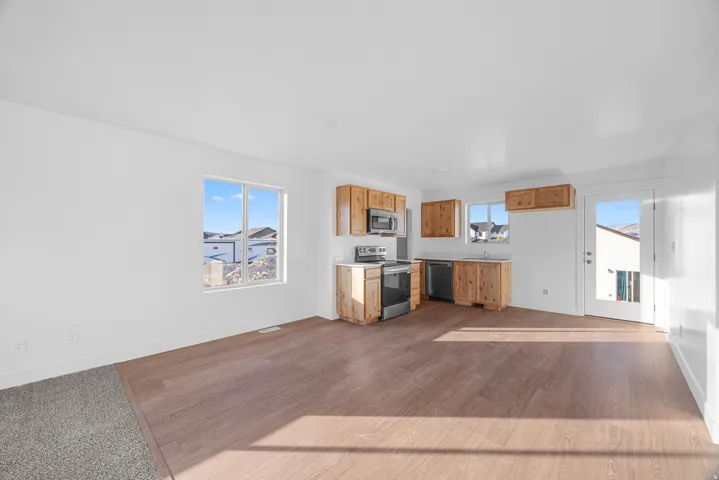 Open-concept living area featuring wood-finish flooring, white walls, and recessed lighting