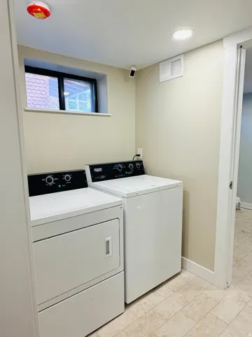 Laundry area featuring light-toned walls, tile flooring, a small window, and recessed ceiling lighting