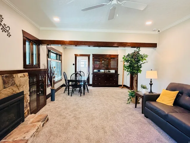 Stone fireplace with wood mantel, built-in wooden cabinetry, recessed lighting, and crown molding