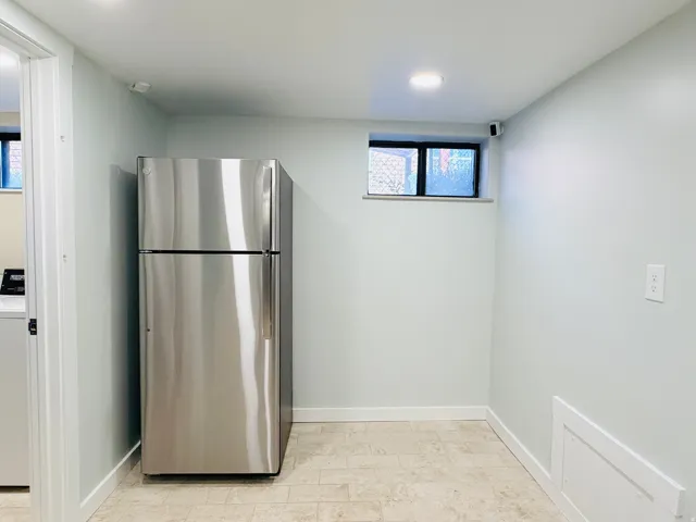 Stainless steel refrigerator, recessed lighting, tile flooring, window, and clean wall finishes