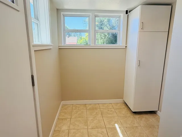 Recessed windows with natural light, tile flooring, and integrated white cabinetry