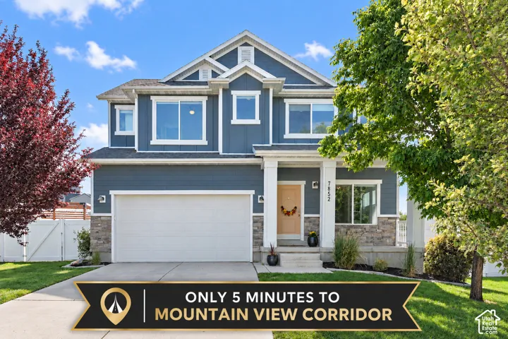 Two-story home with a two-car garage, stone and siding exterior, and a concrete driveway