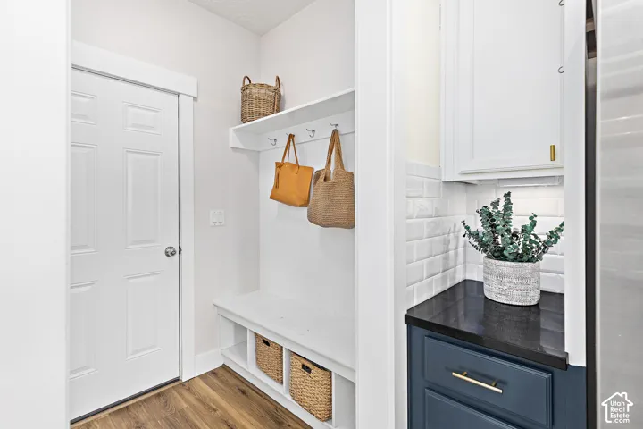 Integrated mudroom area featuring a built-in bench, hooks, and upper shelf