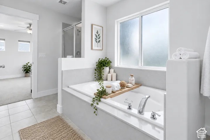 Built-in soaking tub with chrome fixtures, frosted glass window, and tiled flooring