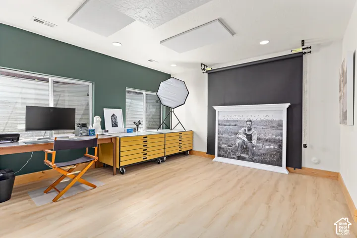Basement bonus room with light wood finish flooring and a bright, open space perfect for an office, game room, or flex space