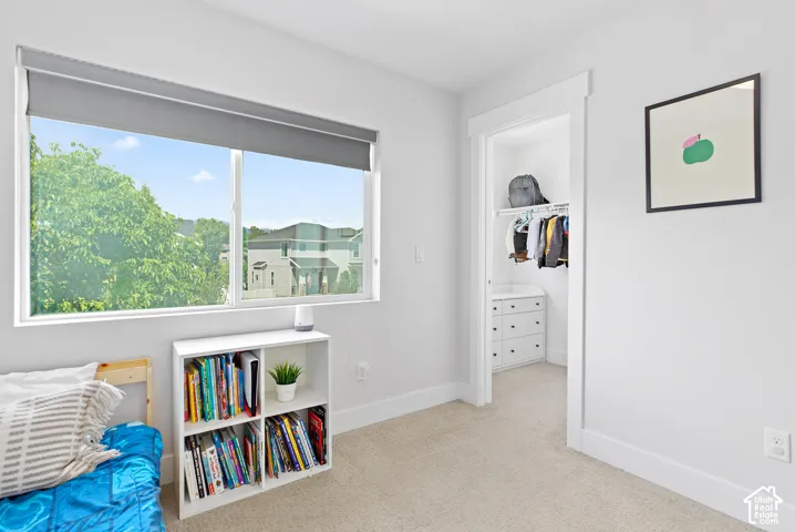 Good size bedroom featuring a large window and walk in closet with a window