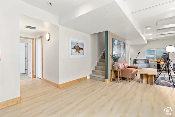 Basement bonus room with light wood finish flooring and a bright, open space perfect for an office, game room, or flex space