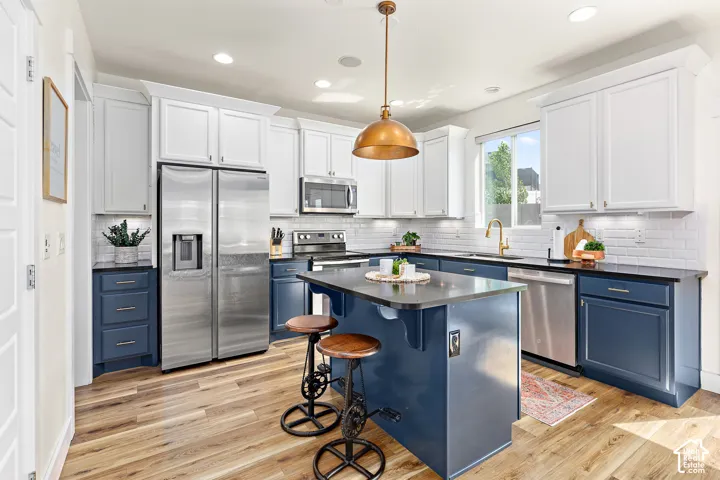 Roomy kitchen with upgraded countertops, abundant cabinetry, center island, custom above bar lighting, double ovens, oversized pantry, and under counter lighting