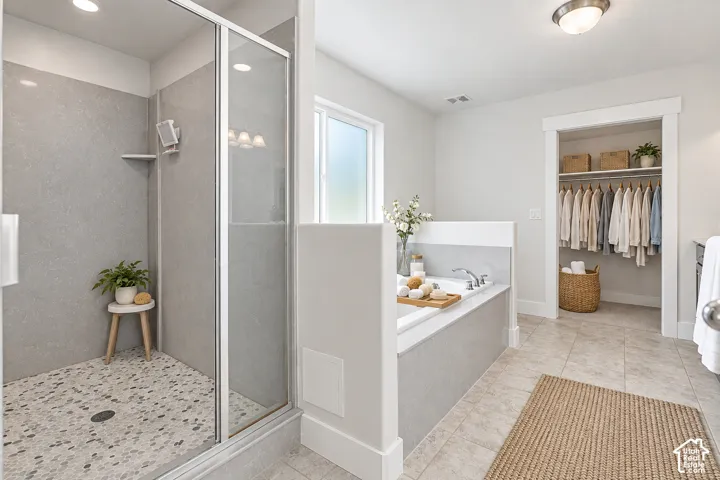 Glass-enclosed shower with dual shower heads, pebble-tile flooring and an integrated shelf