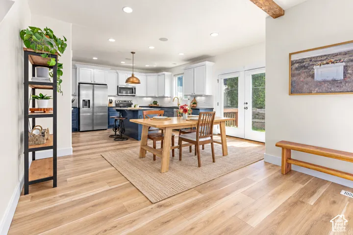 Open-concept kitchen and dining area featuring medium toned wood-finish flooring