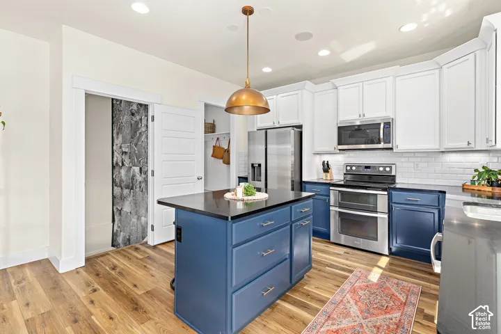 Roomy kitchen with upgraded countertops, abundant cabinetry, center island, custom above bar lighting, double ovens, oversized pantry, and under counter lighting