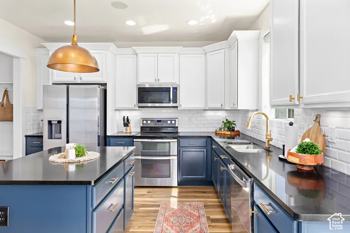 Roomy kitchen with upgraded countertops, abundant cabinetry, center island, custom above bar lighting, double ovens, oversized pantry, and under counter lighting