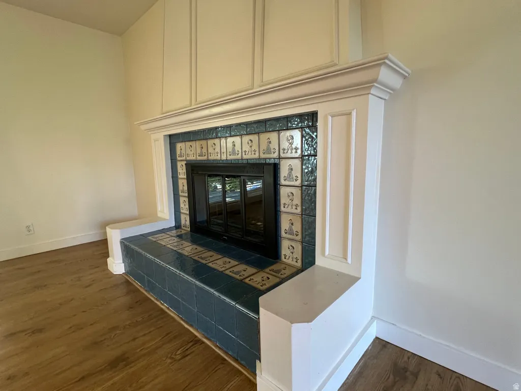 Fireplace with Dutch-style decorative tile surround and hearth, featuring a black firebox and mantle with integrated cabinetry