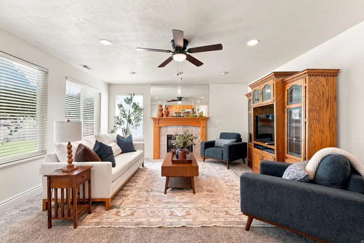 Recessed lighting, ceiling fan, and multiple windows illuminate the space