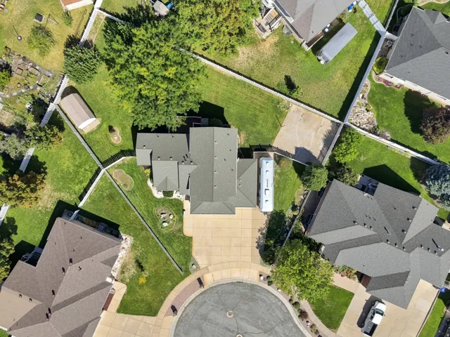 Expansive lot featuring mature trees, a large paved driveway, and multiple outbuildings