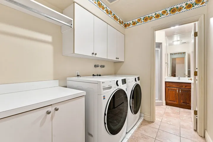 Laundry area featuring white cabinetry, integrated countertop, and tiled flooring