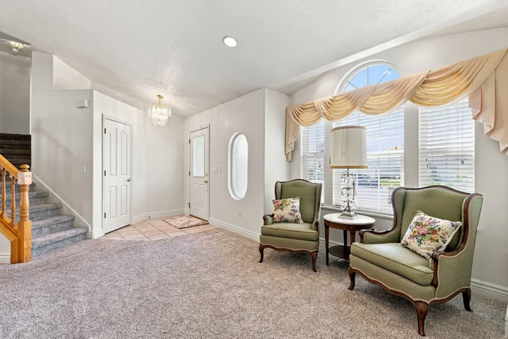 Recessed lighting, arched window, vaulted ceiling, tile flooring, and a crystal chandelier