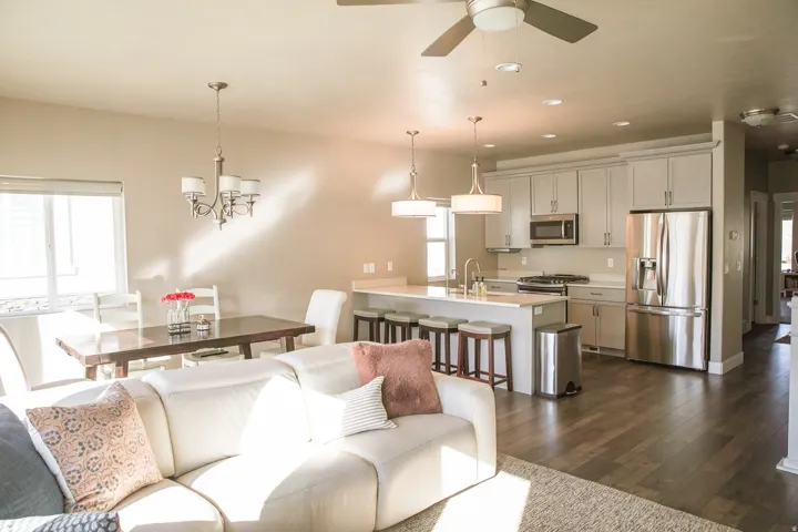 Open-concept living area with wood-finish flooring, a kitchen island, and stainless steel appliances