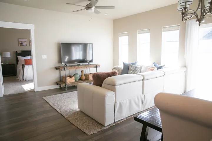 Wood-finish flooring throughout, ceiling fan, multiple windows with blinds, and a built-in window seat