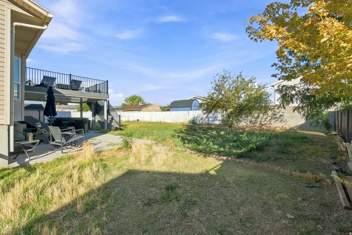 Two-story exterior deck with dark railings, concrete patio.