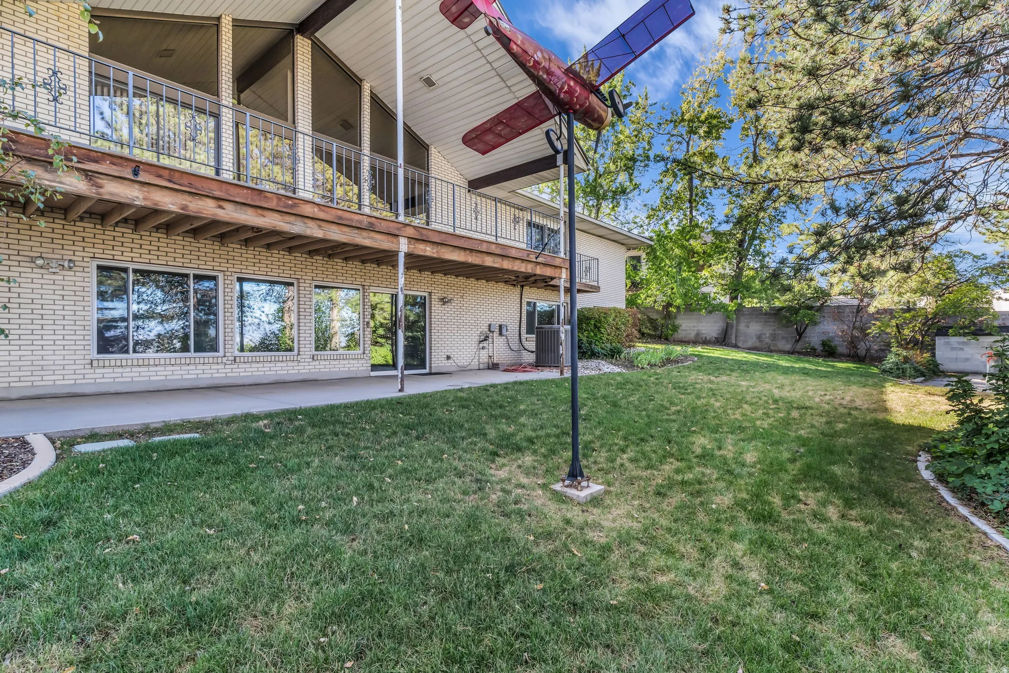 Lower level featuring multiple windows and a glass door providing access to the concrete patio