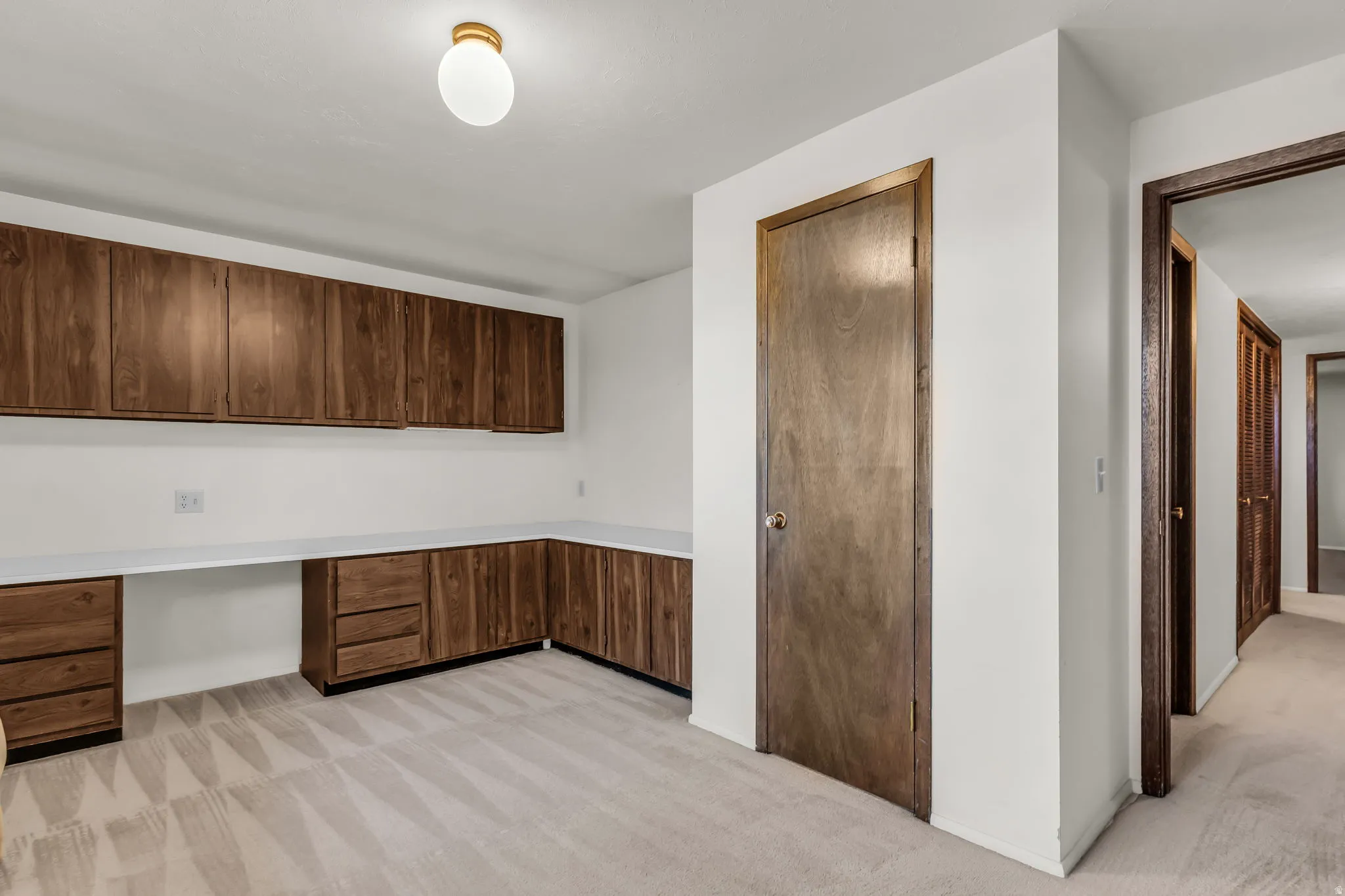 Built-in cabinetry with wood-finish doors, expansive white countertops, and integrated drawers