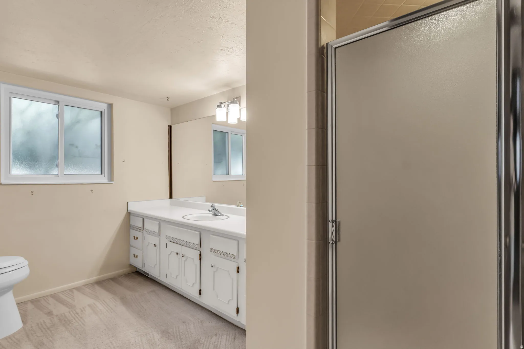 White vanity with integrated sink, white countertop, and chrome faucet