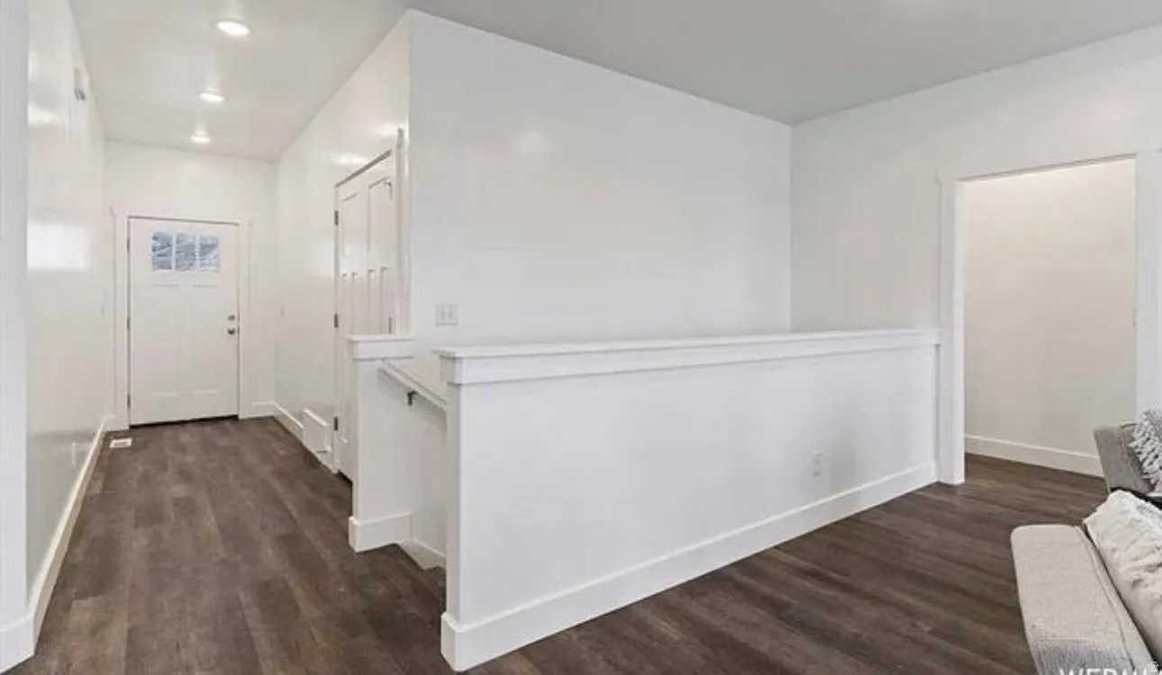 Laminate wood-finish flooring, recessed lighting, and white trim accents