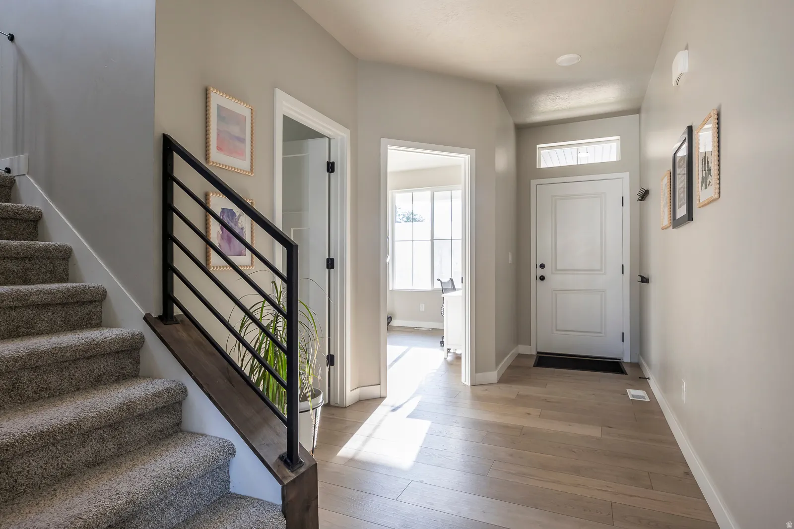 Entryway featuring wood-finish flooring, a white paneled door with transom window, and recessed lighting