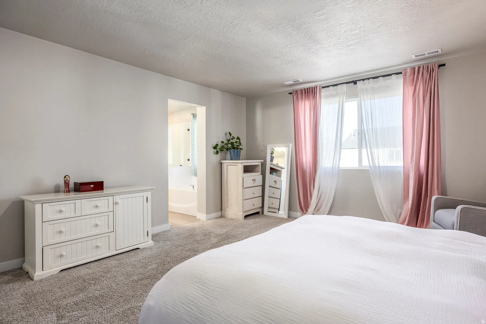 Carpeted room with a rectangular window, light gray walls, and a recessed doorway