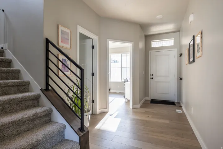Entryway featuring wood-finish flooring, a white paneled door with transom window, and recessed lighting