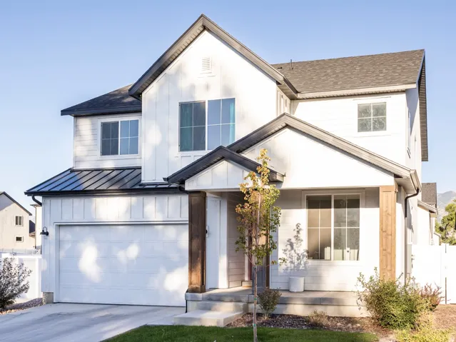 Contemporary two-story exterior with white vertical siding and dark trim