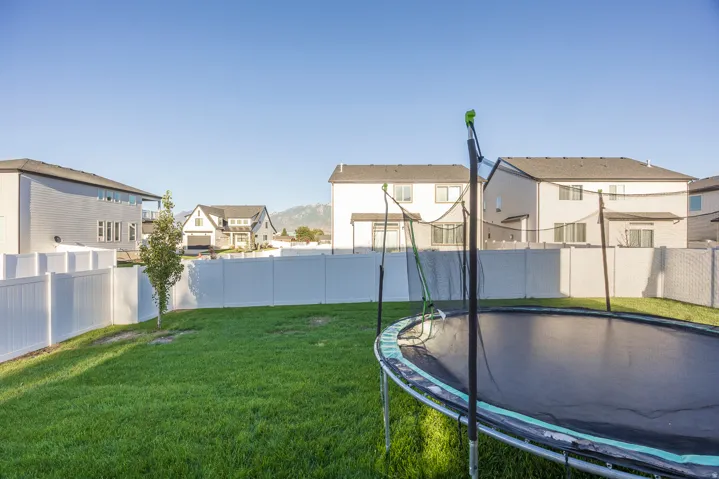 Expansive lawn area with a white privacy fence