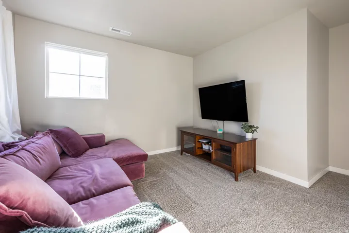 Window with white frame, light-toned walls, and grey patterned carpeting