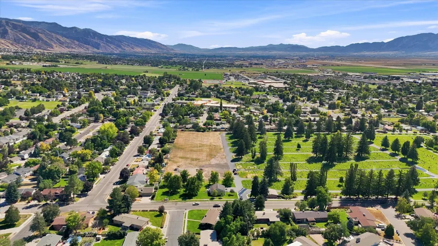 Expansive rural setting with a clear blue sky, distant mountains, and established neighborhood infrastructure