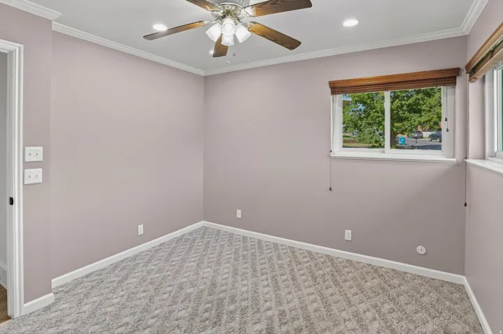Recessed lighting, crown molding, and patterned carpet flooring