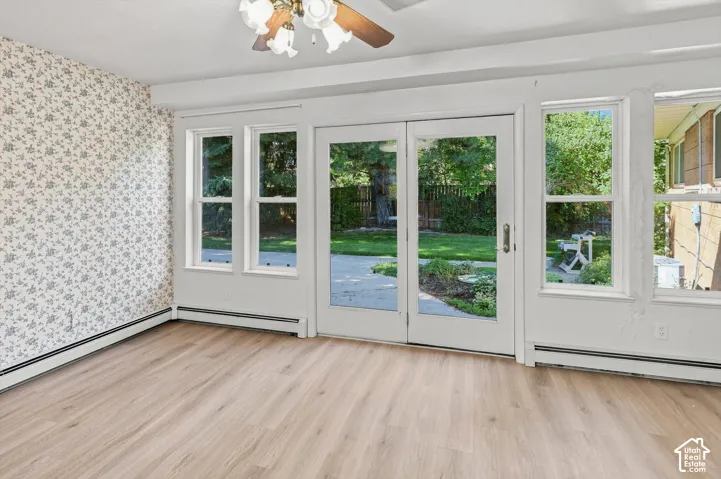 Wood-finish flooring, white trim, and a ceiling fan with light fixture