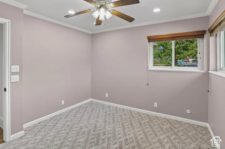Recessed lighting, crown molding, and patterned carpet flooring