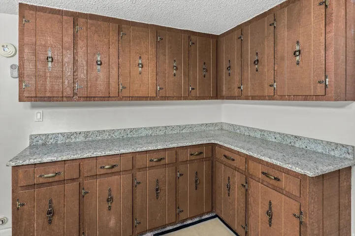 Wrap-around wood-finish cabinetry featuring decorative hardware