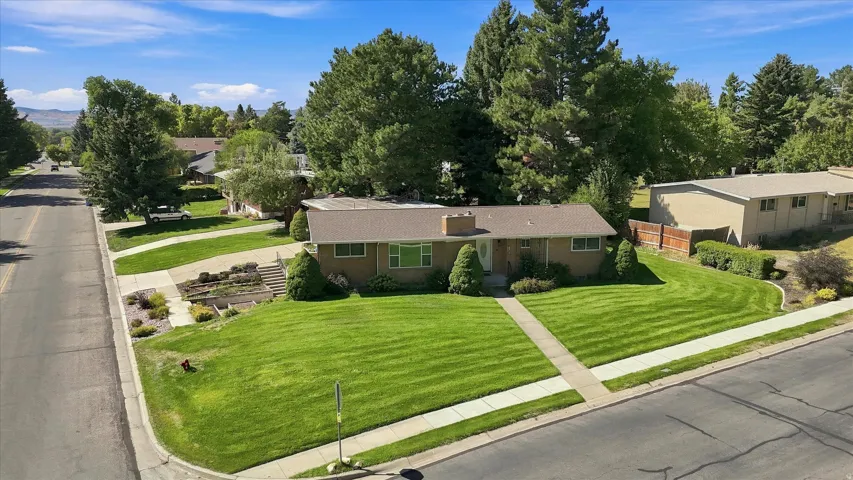 Corner lot residence featuring a brick exterior and a gabled roof
