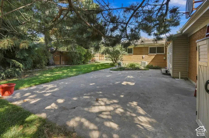Expansive concrete patio with a surrounding lawn
