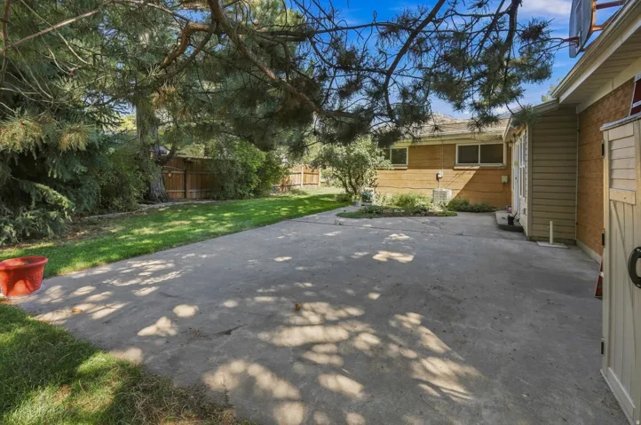 Expansive concrete patio with a surrounding lawn