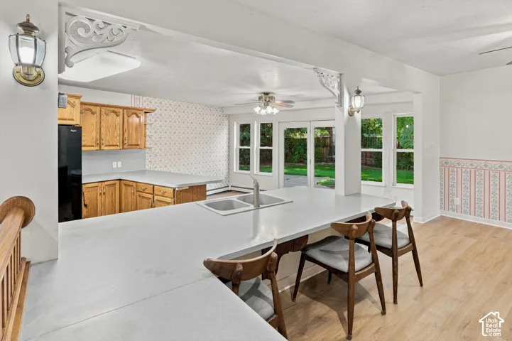 Kitchen featuring a double basin sink, light wood-finish cabinetry, and a peninsula countertop