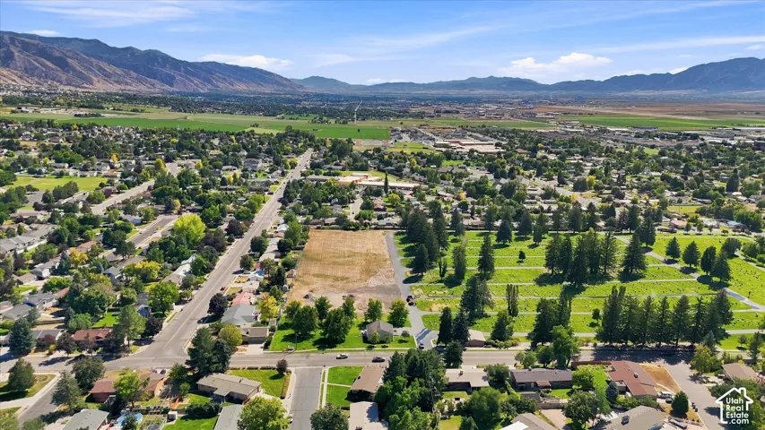 Expansive rural setting with a clear blue sky, distant mountains, and established neighborhood infrastructure