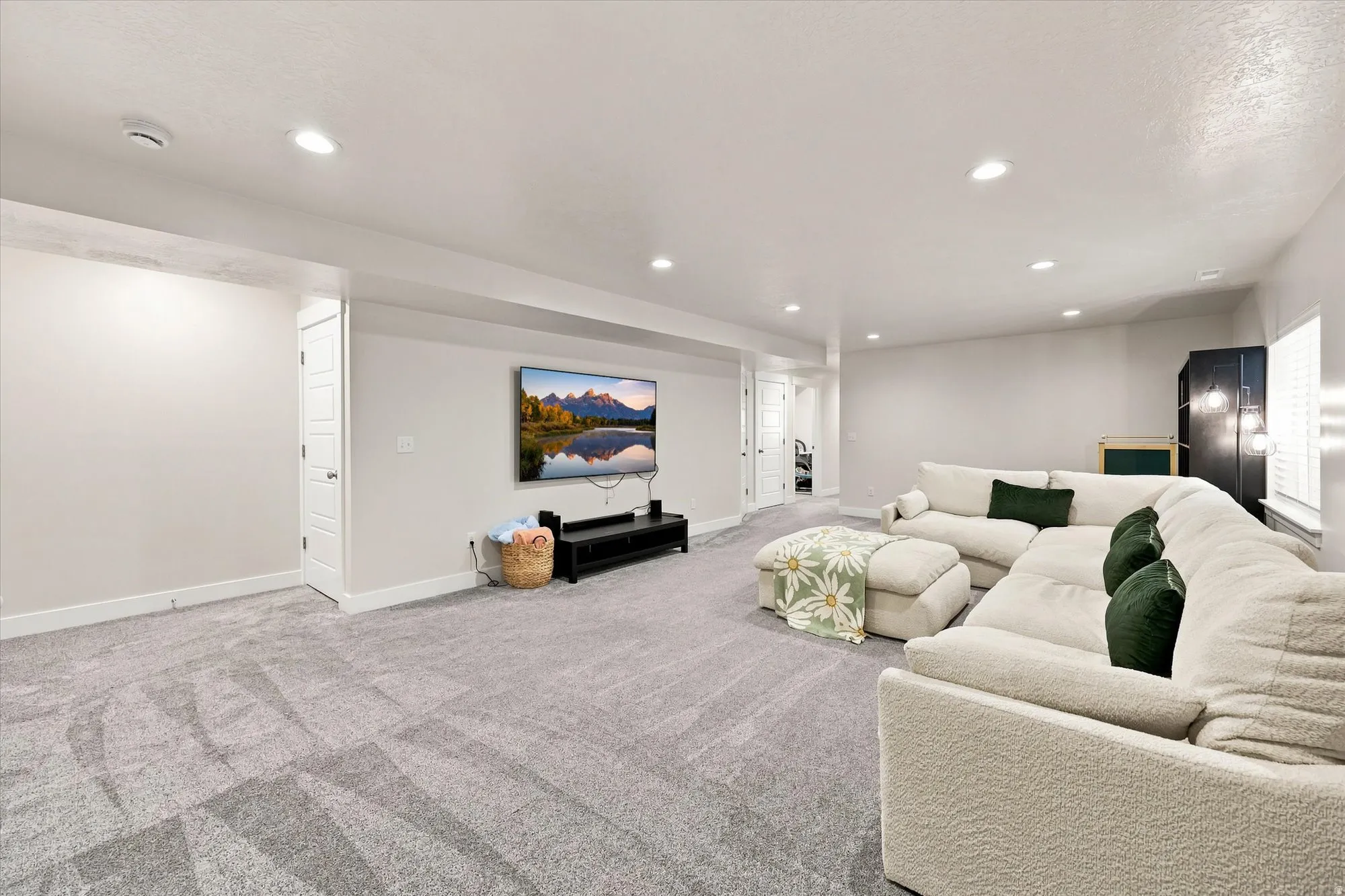 Spacious room featuring neutral carpeting, recessed lighting, and crisp white walls