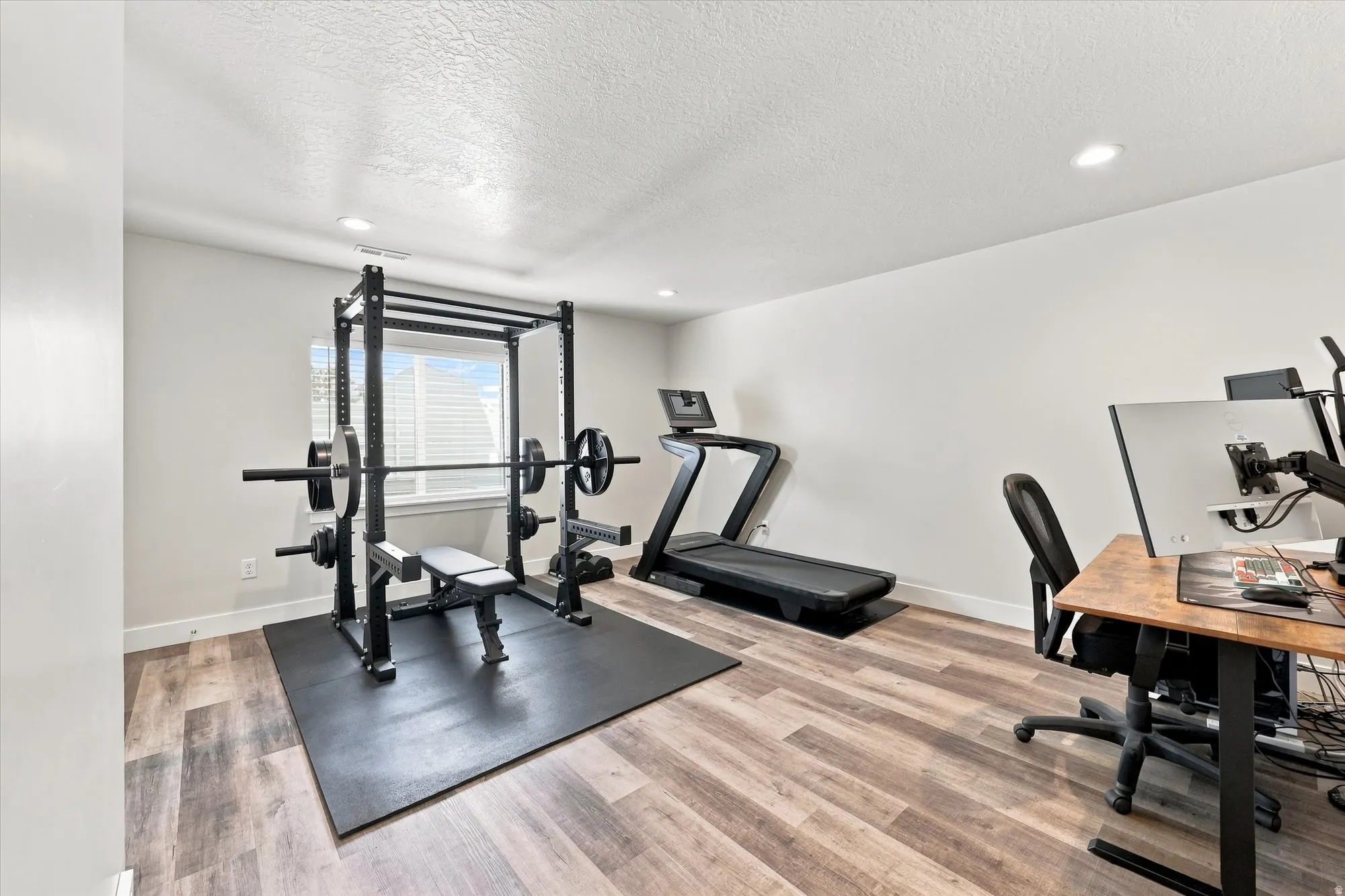 Recessed lighting, wood-finish flooring, and a window with blinds