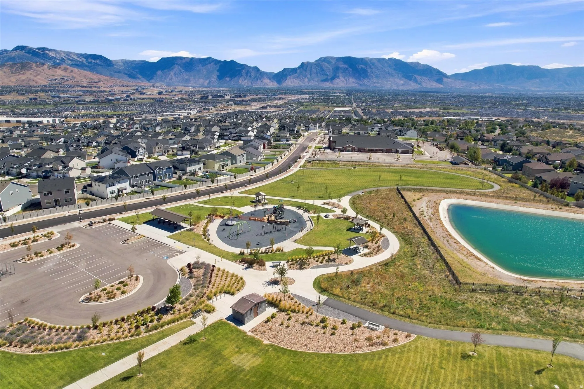 Expansive green spaces featuring a playground, paved walking paths, and a water feature