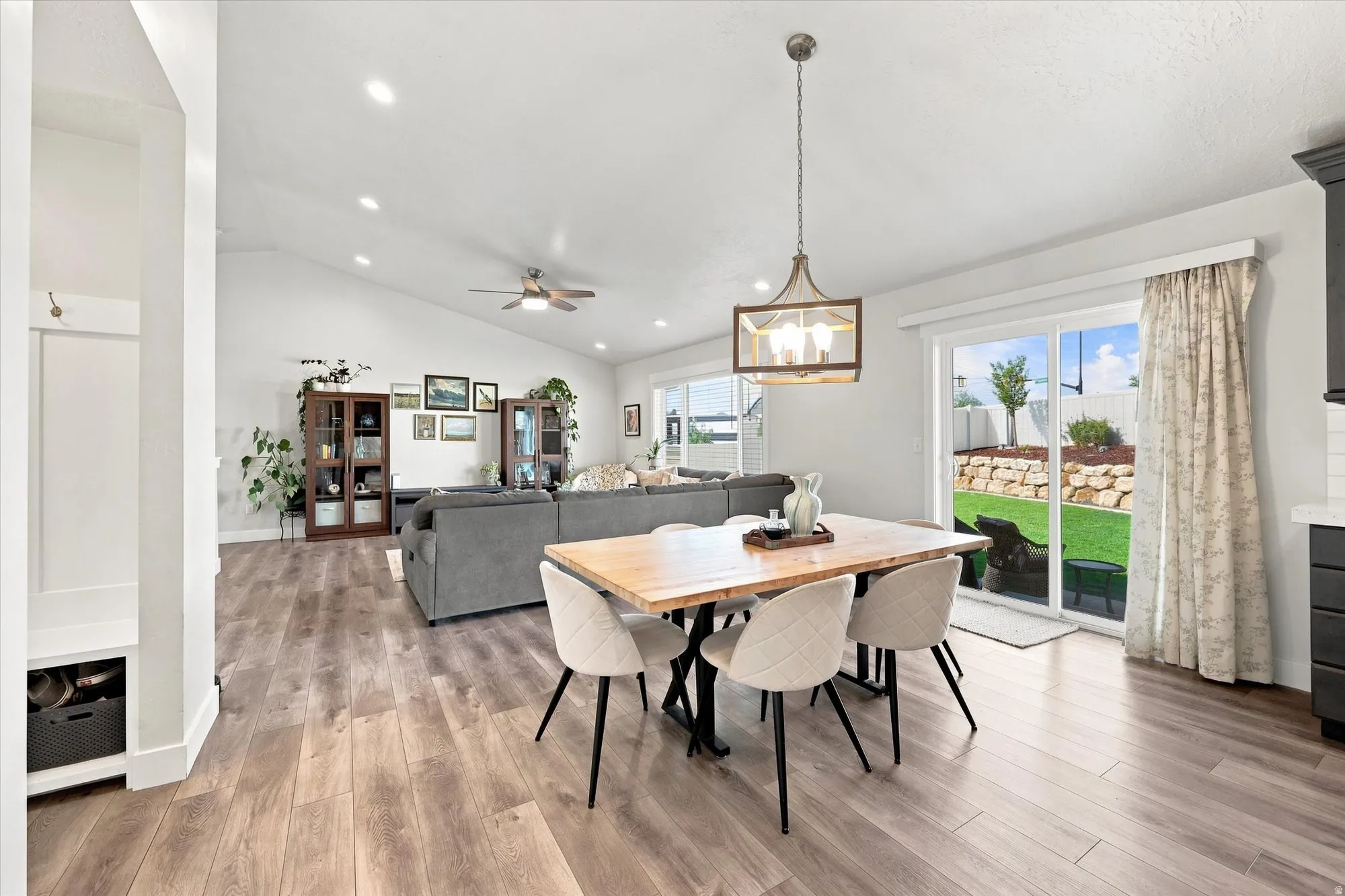 Vaulted ceilings, recessed lighting, wood-finish flooring, a ceiling fan, and sliding glass doors leading to the exterior