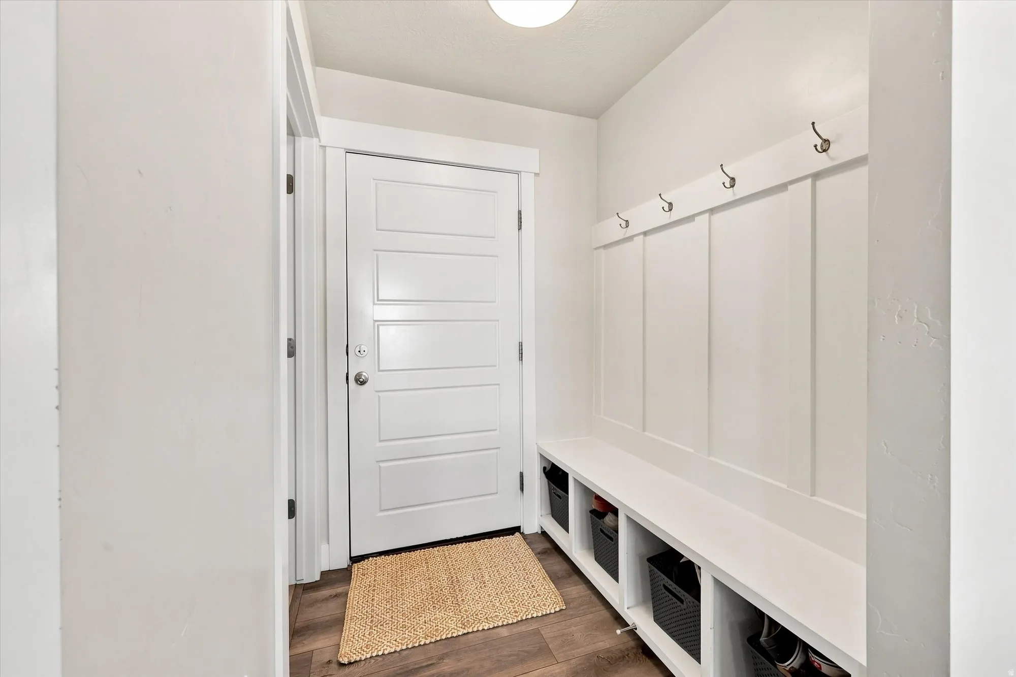 Entryway featuring a built-in bench with storage cubbies, board and batten detailing, and a modern five-panel interior door