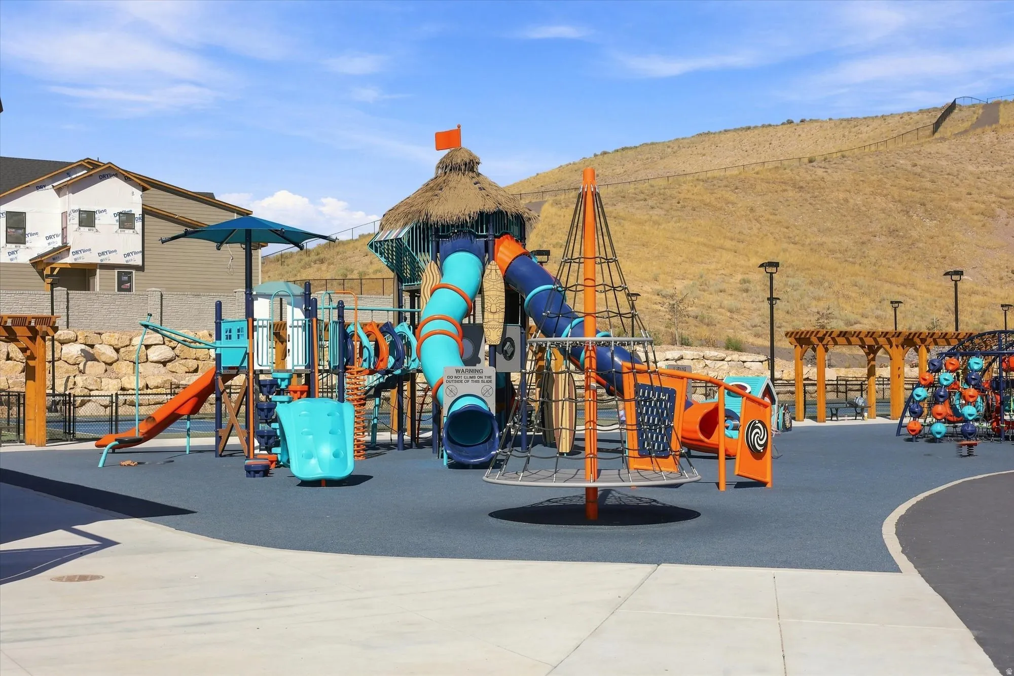 Outdoor play area featuring multiple slides, climbing structures, and protective surfacing